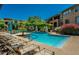 A community pool with lounge chairs, umbrellas, and lush landscaping provides a resort-style experience at 20100 N 78Th Pl # 2203, Scottsdale, AZ 85255