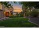 Expansive backyard with lush green lawn, mature landscaping, and covered patio at 21525 E Camacho Rd, Queen Creek, AZ 85142