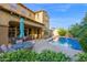 Inviting patio space with an outdoor dining set, complemented by the serene pool and verdant greenery at 21525 E Camacho Rd, Queen Creek, AZ 85142