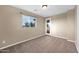 An empty room with tan walls and beige carpet at 21525 E Camacho Rd, Queen Creek, AZ 85142