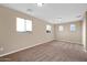 Spacious bedroom featuring neutral walls, carpet, windows with arched details, and a ceiling light at 21525 E Camacho Rd, Queen Creek, AZ 85142