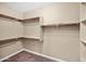 Walk-in closet with rod and shelf storage plus neutral carpeting and paint at 21525 E Camacho Rd, Queen Creek, AZ 85142