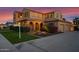 Elegant home with arched entry, lush landscaping, and a spacious driveway at 21525 E Camacho Rd, Queen Creek, AZ 85142
