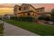 Spacious home with manicured lawn, mature shrubbery, and a welcoming arched entrance at 21525 E Camacho Rd, Queen Creek, AZ 85142