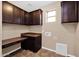 Laundry room with dark cabinets, tan walls, and a brown countertop at 21525 E Camacho Rd, Queen Creek, AZ 85142