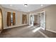 Spacious living room with neutral tones, ample natural light, and French doors leading to another room at 21525 E Camacho Rd, Queen Creek, AZ 85142
