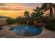 Backyard oasis with a freeform pool, rock waterfall, and lush tropical landscaping providing a private retreat at 21525 E Camacho Rd, Queen Creek, AZ 85142