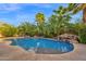 Tropical backyard oasis with a lagoon-style pool, waterfall, and lush landscaping at 21525 E Camacho Rd, Queen Creek, AZ 85142