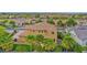 Expansive two-story home featuring desert landscaping, tile roof, and a lush backyard with tall palms at 21525 E Camacho Rd, Queen Creek, AZ 85142