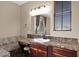 Bathroom vanity with a marble countertop, dark wood cabinets, and decorative tile backsplash at 21525 E Camacho Rd, Queen Creek, AZ 85142