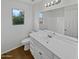 Bathroom featuring a single sink vanity, white cabinets, and a large mirror with lighting at 217 E Gwen St, Phoenix, AZ 85042