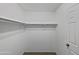 A walk-in closet featuring neutral carpet, a door, and a shelf with hanging space at 217 E Gwen St, Phoenix, AZ 85042