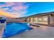 Backyard oasis featuring a refreshing pool, stone accents, lush landscaping, and a covered patio at 22884 E Via De Olivos --, Queen Creek, AZ 85142