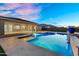 Inviting pool area featuring stone pavers, desert landscaping, and covered patio with outdoor seating at 22884 E Via De Olivos --, Queen Creek, AZ 85142