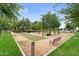 Scenic bocce ball court with benches and mature trees, offering a perfect spot for outdoor recreation and relaxation at 22884 E Via De Olivos --, Queen Creek, AZ 85142