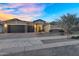 Beautiful single-Gathering home featuring a three-car garage, stone accents, desert landscaping, and a paver driveway at 22884 E Via De Olivos --, Queen Creek, AZ 85142