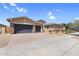 Charming single-Gathering home showcasing a three-car garage, desert landscaping, and a paver driveway at 22884 E Via De Olivos --, Queen Creek, AZ 85142