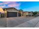 Attractive house featuring a brick driveway, three-car garage, desert landscaping, and stone veneer accents at 22884 E Via De Olivos --, Queen Creek, AZ 85142