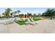 Inviting pool-side lounge area with colorful umbrellas, lounge chairs, and lush greenery at 22884 E Via De Olivos --, Queen Creek, AZ 85142
