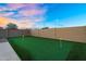 Backyard putting green offers a recreational area for golf enthusiasts with lush green turf and clear skies at 22884 E Via De Olivos --, Queen Creek, AZ 85142