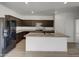 Modern kitchen featuring dark cabinets, stainless steel appliances, and a large center island at 2367 E Rosario Mission Dr, Casa Grande, AZ 85194