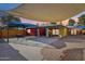 Large backyard featuring a covered patio, desert landscaping, and colorful exterior walls at 2511 E Pinchot Ave, Phoenix, AZ 85016