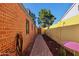The property has a cozy side yard featuring a brick pathway and colorful accents at 2511 E Pinchot Ave, Phoenix, AZ 85016