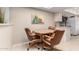Cozy dining area with wood table, comfortable chairs, and view to the kitchen at 25238 S Mohawk Dr, Sun Lakes, AZ 85248
