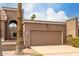 Close up of a large two car brown garage door with address numbers and desert landscaping at 25238 S Mohawk Dr, Sun Lakes, AZ 85248