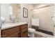 Bathroom featuring a wood vanity, tiled shower with glass door, toilet, and artwork at 26999 W Ponderosa Ln, Buckeye, AZ 85396