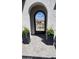 Arched entry gate with an ornate metal design and planters on either side of the walkway at 26999 W Ponderosa Ln, Buckeye, AZ 85396