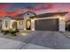 Stunning home exterior with a well-manicured front yard at dusk, showcasing its curb appeal at 26999 W Ponderosa Ln, Buckeye, AZ 85396