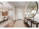 Bright foyer with modern console table, round mirror, and views into the dining area at 26999 W Ponderosa Ln, Buckeye, AZ 85396