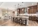 Open kitchen with a large island, breakfast bar, stainless appliances, and modern pendant lighting at 26999 W Ponderosa Ln, Buckeye, AZ 85396