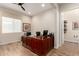 Home office featuring a large desk, wood-look floors, and a view into an attached bathroom at 26999 W Ponderosa Ln, Buckeye, AZ 85396