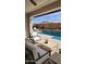 Covered patio with stylish outdoor seating overlooking the pool and desert landscape at 26999 W Ponderosa Ln, Buckeye, AZ 85396