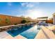 Backyard pool featuring a waterfall feature, outdoor seating, and lush landscaping at 26999 W Ponderosa Ln, Buckeye, AZ 85396