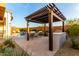 Outdoor kitchen with a pergola and a BBQ adjacent to the relaxing pool at 26999 W Ponderosa Ln, Buckeye, AZ 85396