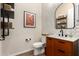 Modern powder room featuring stylish decor, tiled backsplash, floating shelves and a vanity at 26999 W Ponderosa Ln, Buckeye, AZ 85396