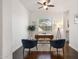 Home office with a ceiling fan, modern desk, two blue chairs, and a view of the lush outdoors at 2896 E Maplewood St, Gilbert, AZ 85297