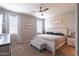 Cozy primary bedroom with carpet floors, ceiling fan, and ample natural light at 31045 W Mulberry Dr, Buckeye, AZ 85396