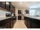 Modern kitchen featuring stainless steel appliances, granite countertops, and dark cabinetry at 31045 W Mulberry Dr, Buckeye, AZ 85396