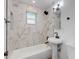 Modern bathroom featuring a white pedestal sink, white toilet, and a tiled shower and tub with marble accents at 3330 E Palm Ln, Phoenix, AZ 85008