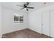 Bright bedroom with wood-look flooring, white walls, a ceiling fan, and a window providing natural light at 3330 E Palm Ln, Phoenix, AZ 85008