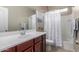 Bathroom showcasing a clean white sink and a shower tub combo with patterned curtains at 37161 W Giallo Ln, Maricopa, AZ 85138