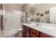 Bathroom features a vanity with solid surface countertops, framed mirror, and updated shower/tub at 37161 W Giallo Ln, Maricopa, AZ 85138