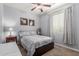 Neutral bedroom featuring patterned bedding, modern ceiling fan, and a bright window at 37161 W Giallo Ln, Maricopa, AZ 85138