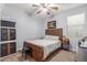 Bedroom featuring a wood bed frame, ceiling fan with a light, and an art piece on the wall at 37161 W Giallo Ln, Maricopa, AZ 85138