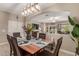 Dining room with wood table and chairs, set for six, with view into the living room at 37161 W Giallo Ln, Maricopa, AZ 85138