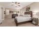 Large main bedroom with a ceiling fan, carpet floors, dresser, and decorative artwork at 37161 W Giallo Ln, Maricopa, AZ 85138